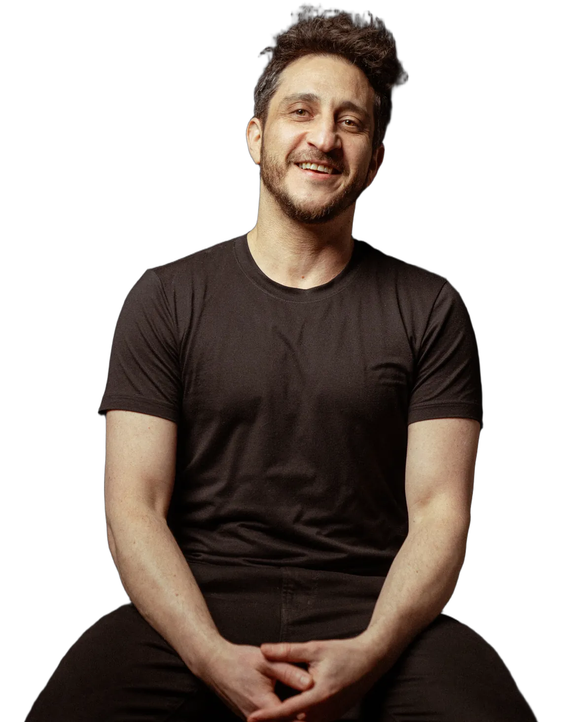 Jesse Elan sitting and smiling, in a black t-shirt